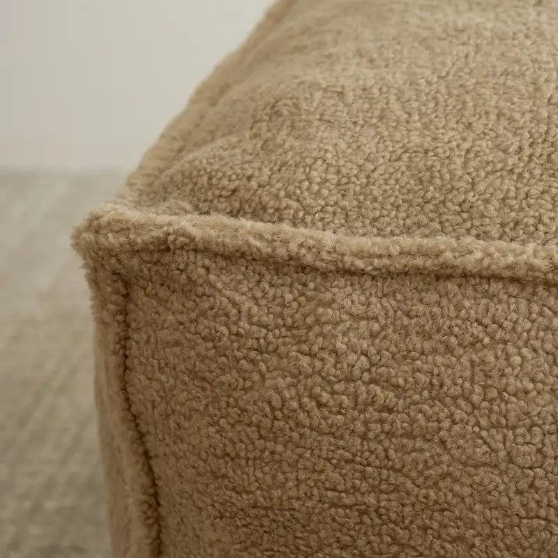 A sectional sofa with a light brown, lambskin-like texture.